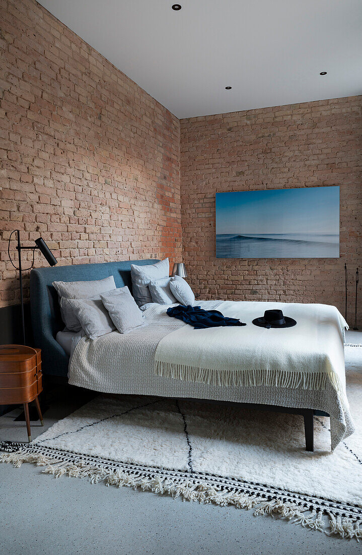 Bedroom with brick wall and large picture