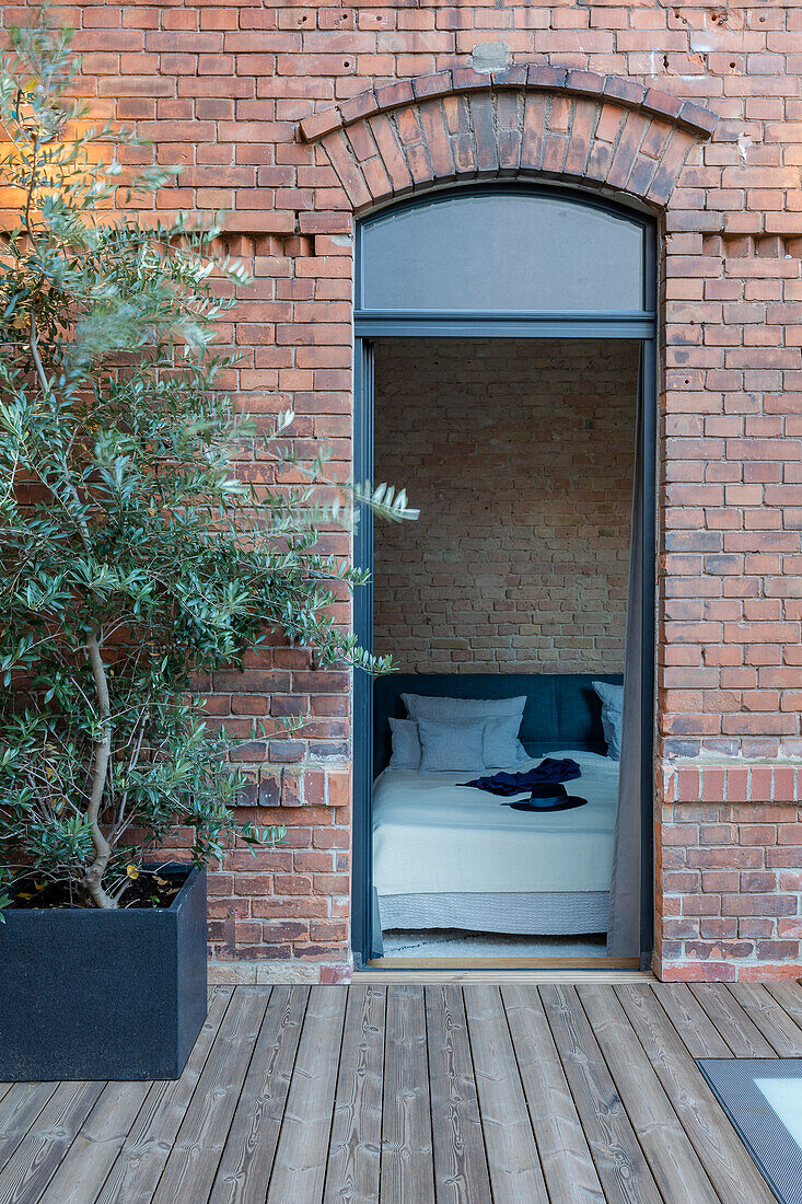 View from terrace to bed, brick wall