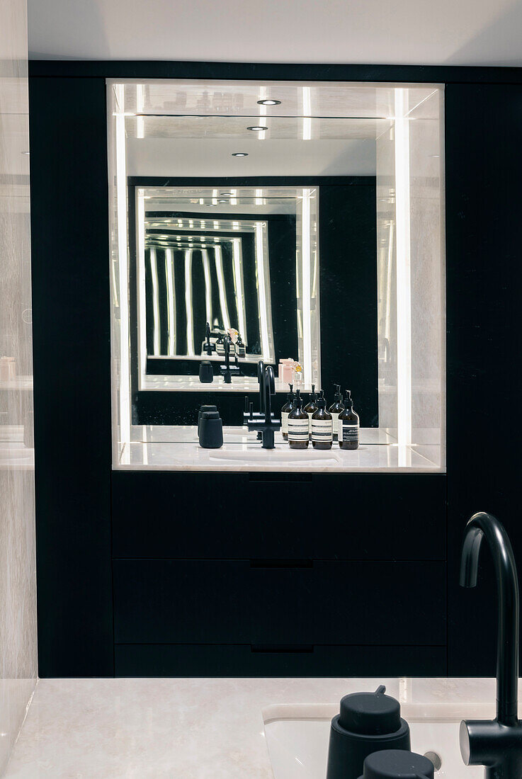 Modern bathroom with LED mirror and black wall