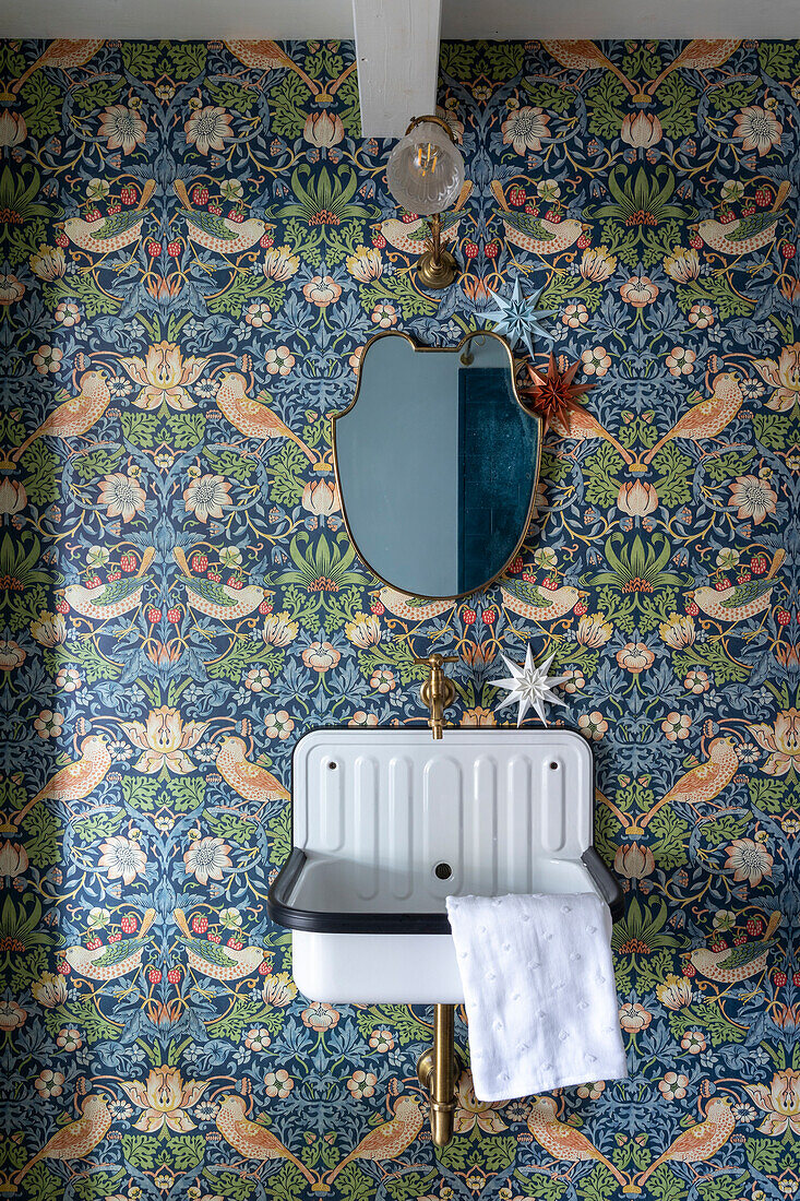 Retro washbasin with mirror, patterned vintage-style wallpaper