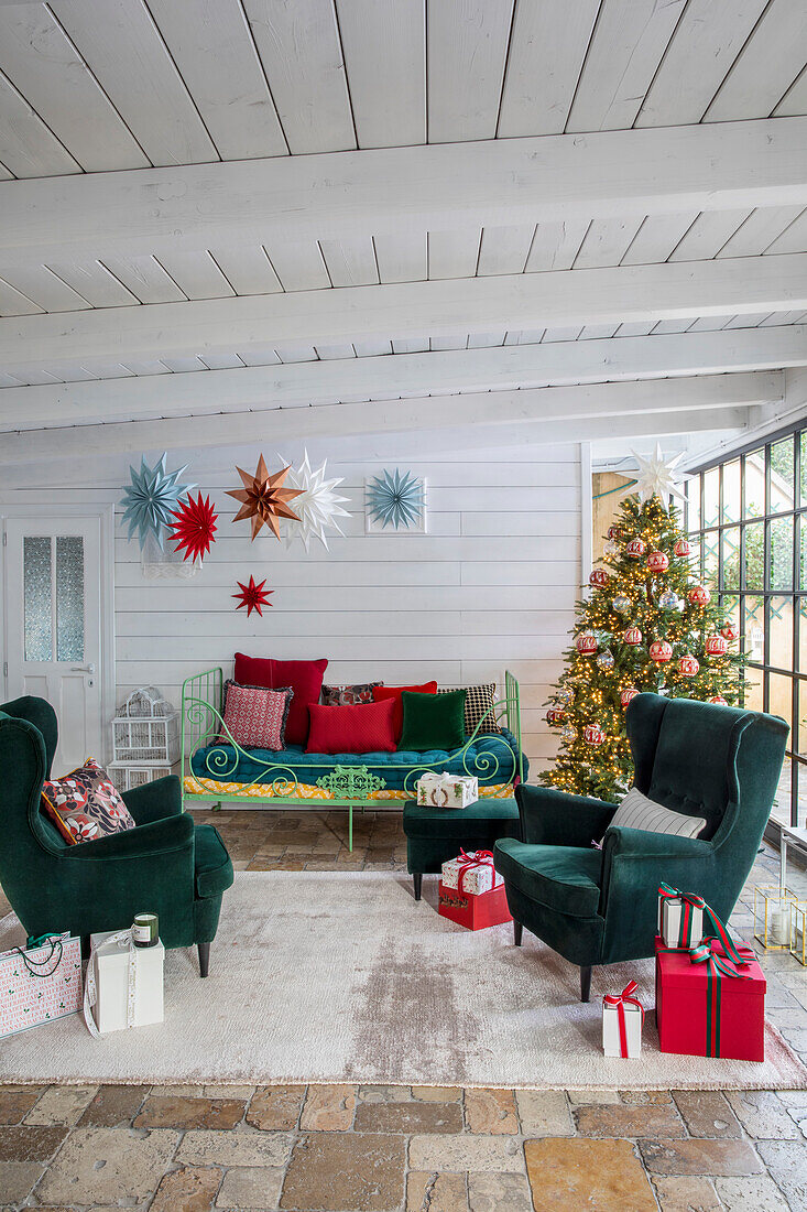 Living room decorated for Christmas with green armchairs and decorative stars