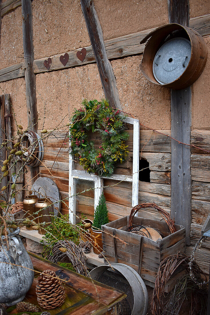 Wreath on old window frame and rustic decorations outside half-timbered house