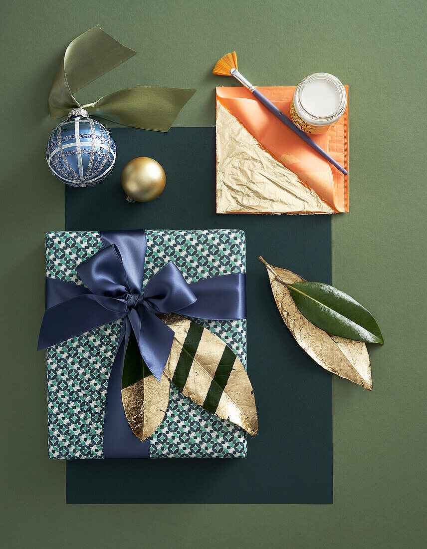 Wrapped gift decorated with gold-leaf leaves