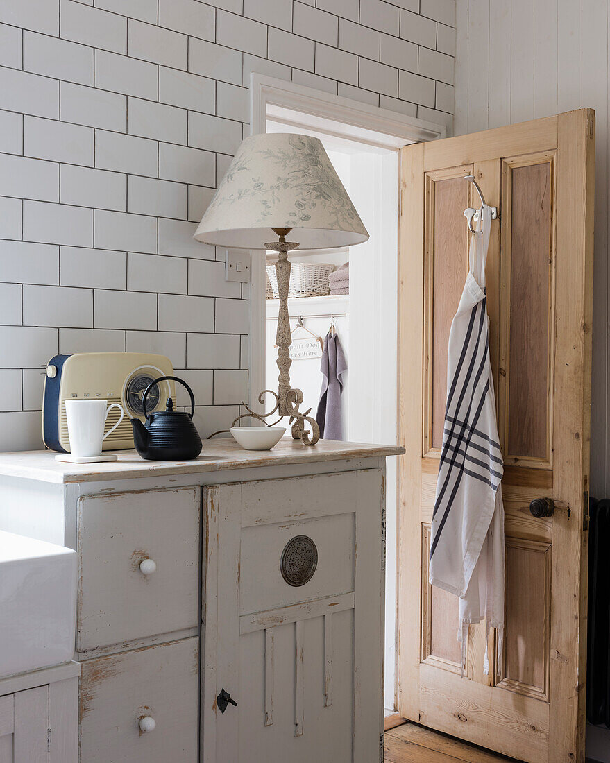 Vintage cupboard with table lamp and retro radio in country-style kitchen