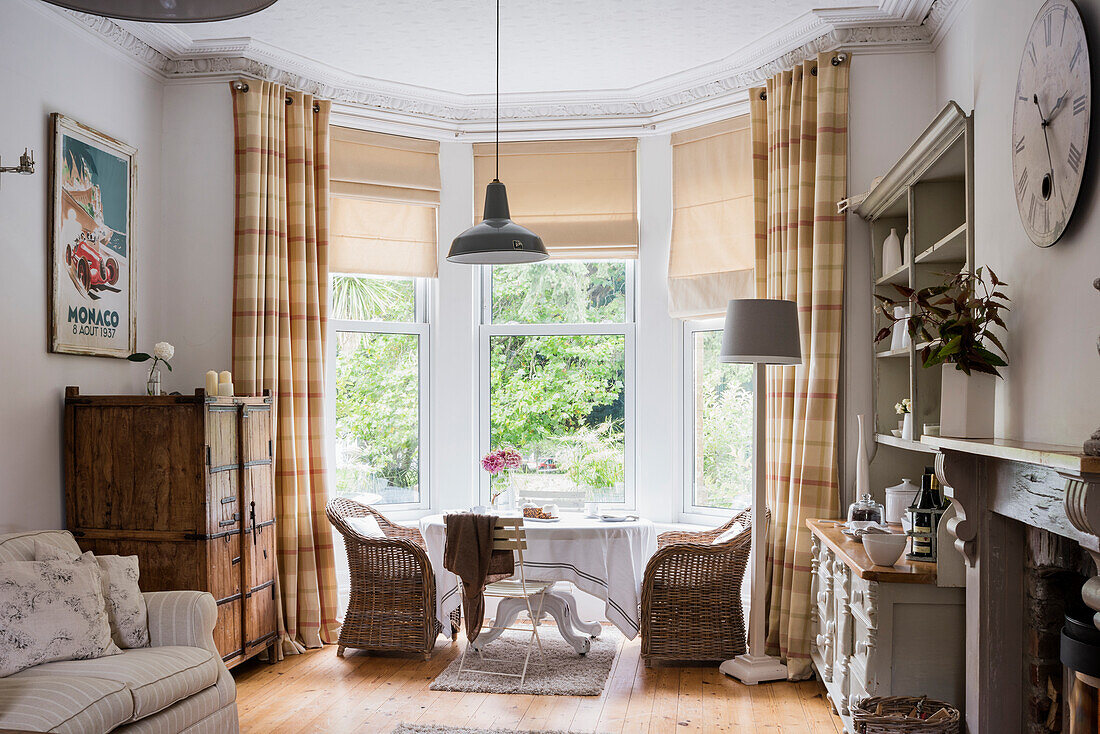 Gemütliches Wohnzimmer mit Rattansesseln und Blick in den Garten