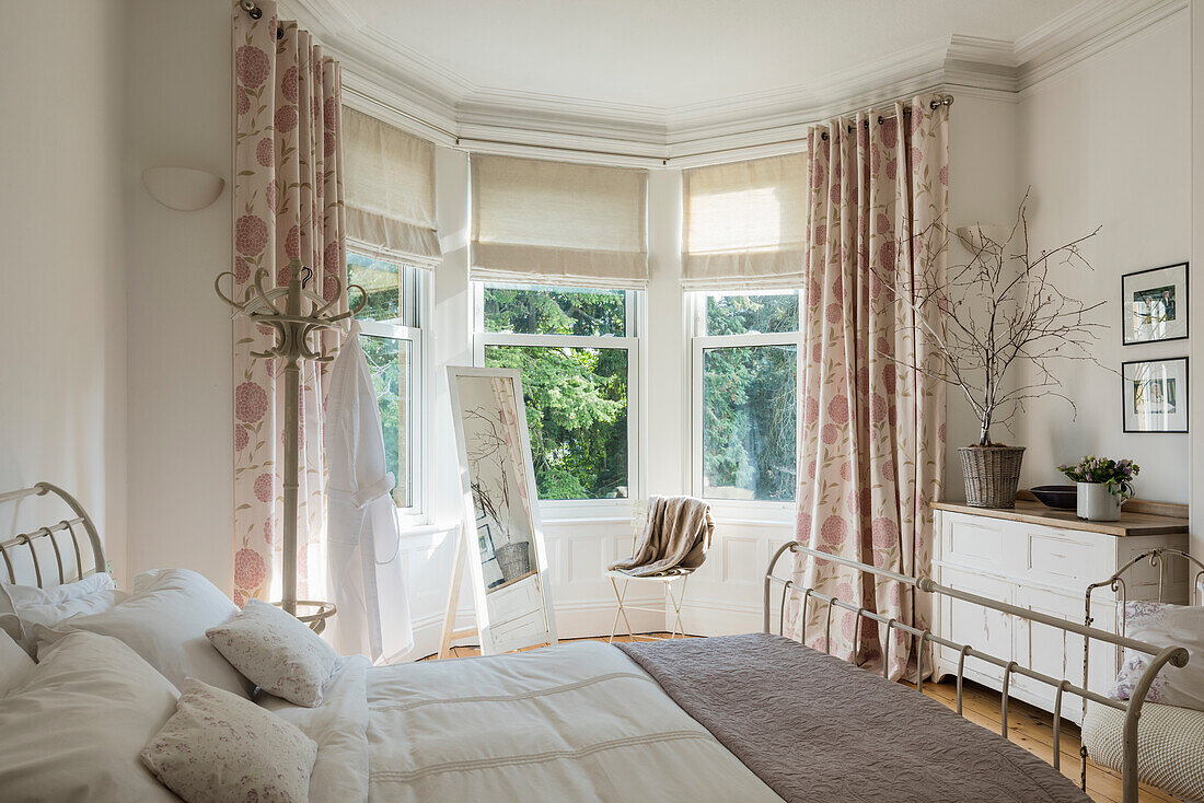 Helles Schlafzimmer mit Erkerfenster und Metall-Bettgestell