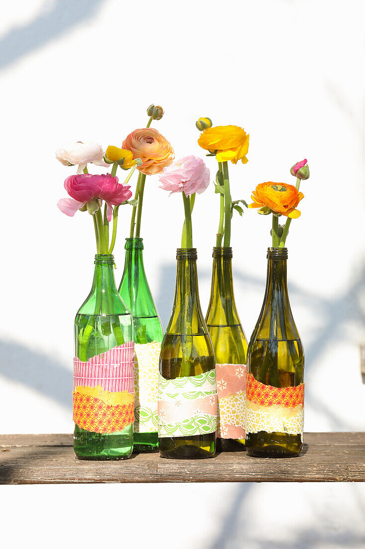 Ranunculus in bottle vases, wrapped with wrapping paper