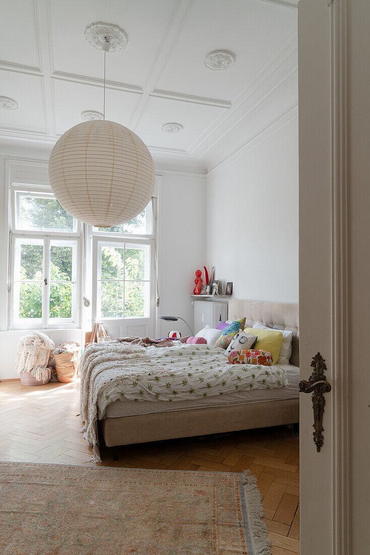 Bright bedroom with stucco ceiling, herringbone parquet flooring and subtle color scheme