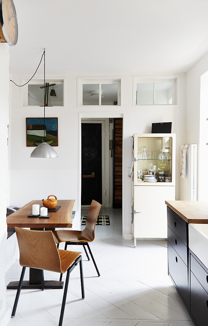 Dining area with wooden table, wooden chairs and vintage display cabinet