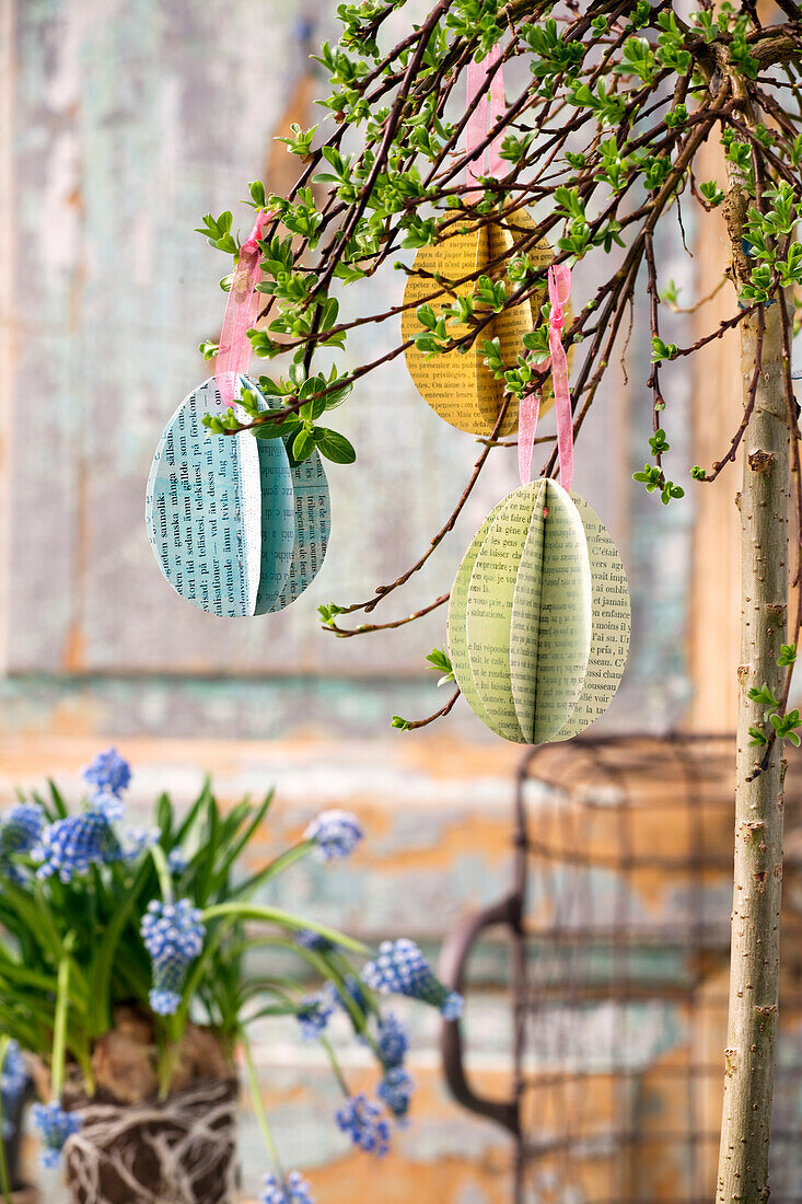 DIY Easter eggs made from book pages hanging from a branch