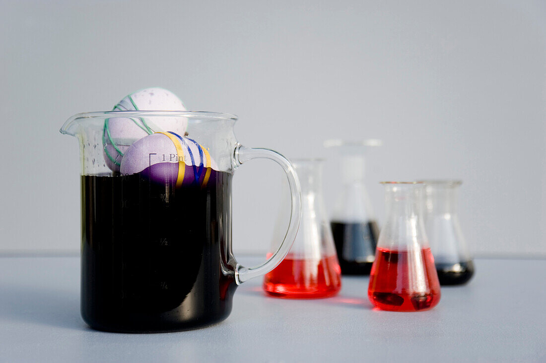Eggs dyed with rubber bands and purple natural colour in measuring flask