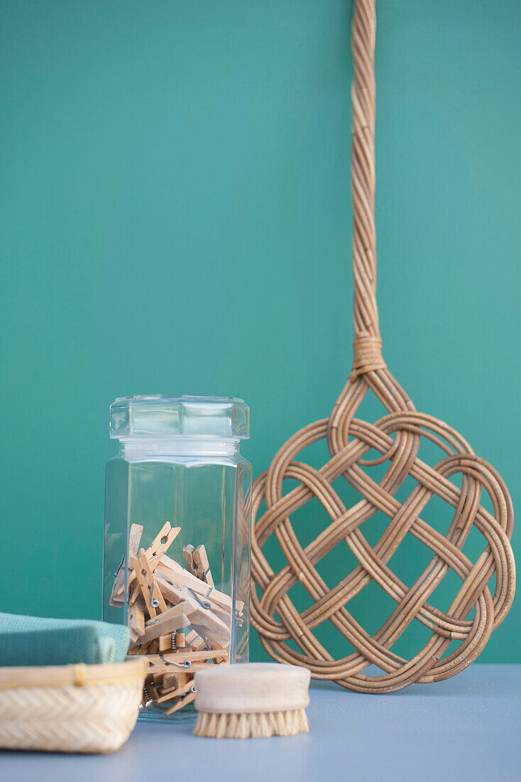 DIY cleaning supplies: retro carpet beater, clothespins in jar, cotton rags and wooden brush
