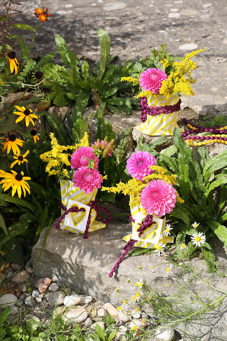 Colourful autumn posies of dahlias and goldenrod in paper bags