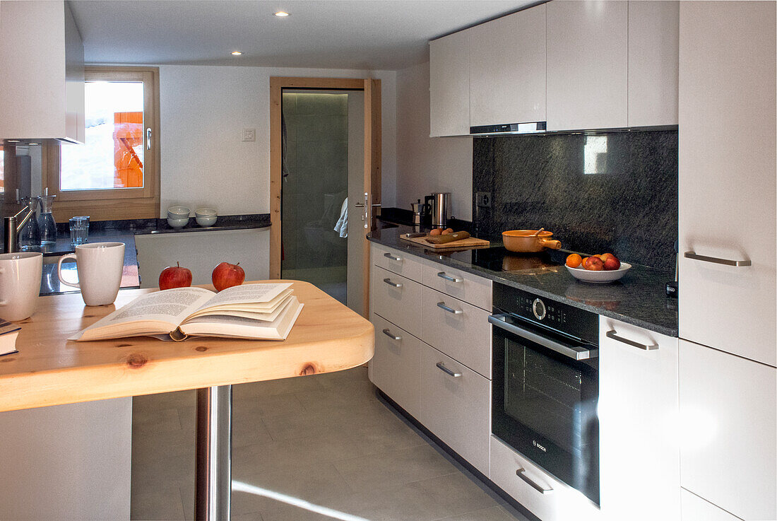 Moderne Küche mit Kochinsel und Holzdetails
