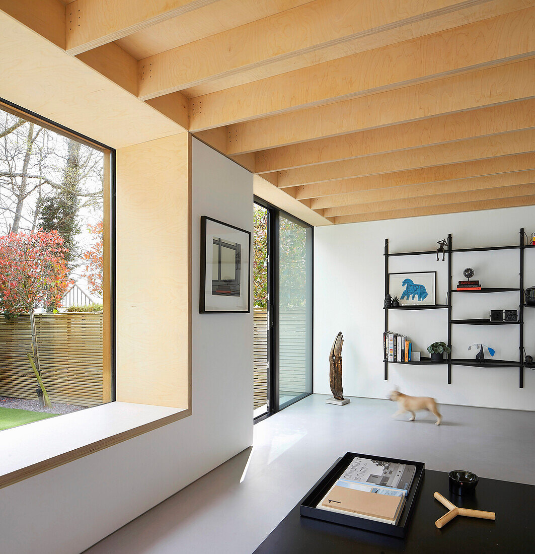 Minimalistisches Wohnzimmer mit Holzdecke und Panoramafenster