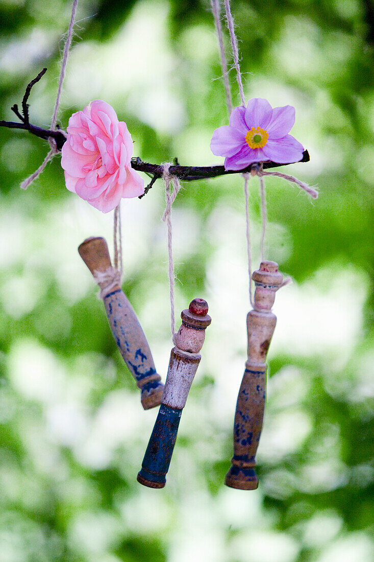Windspiel aus altem Holzspielzeug und Blüten