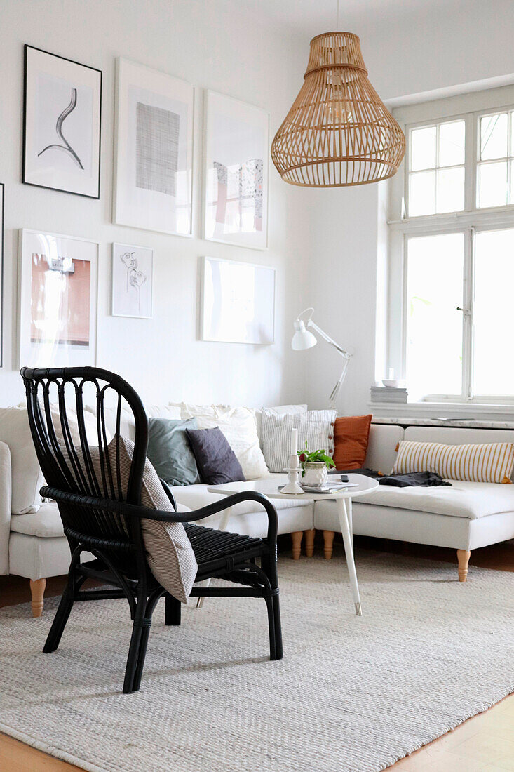 Scandinavian-inspired living room with rattan chair and picture wall