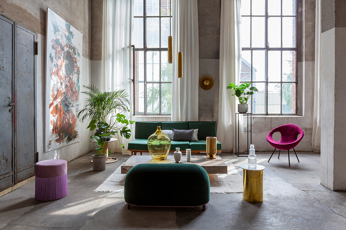 Loft-Wohnzimmer mit Retrosofa, Pflanzen und großen Fenstern