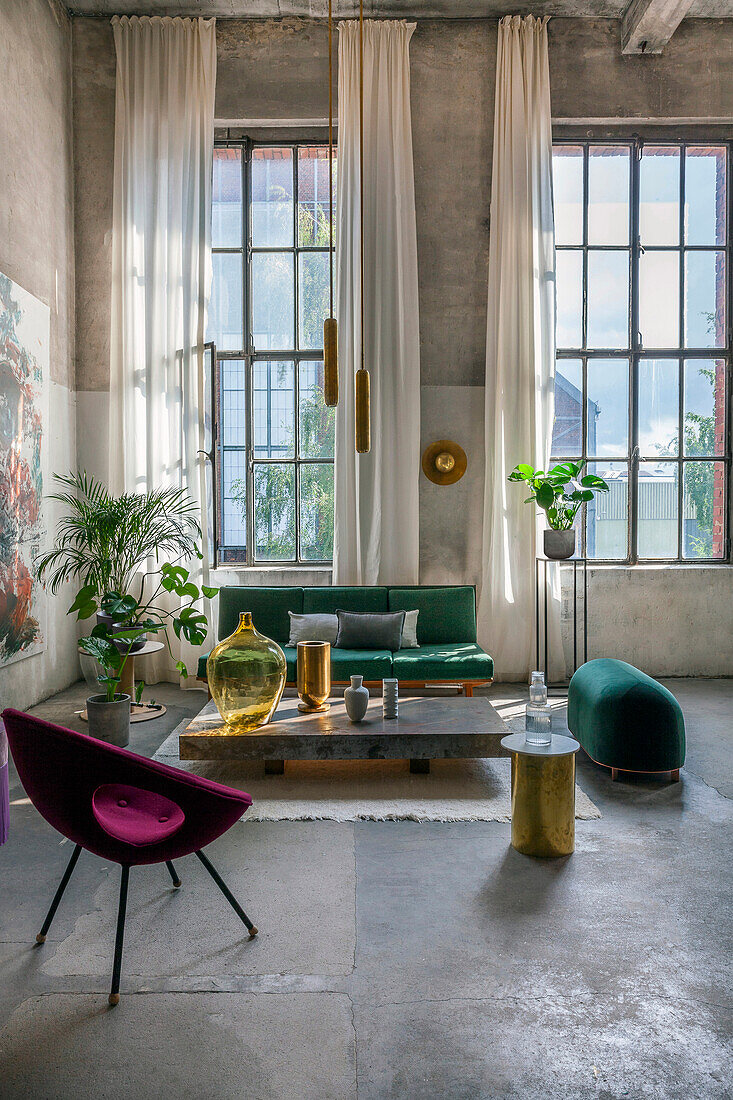 Wohnzimmer im Industrial-Design mit Retro-Samtcouch und goldfarbenen Akzenten