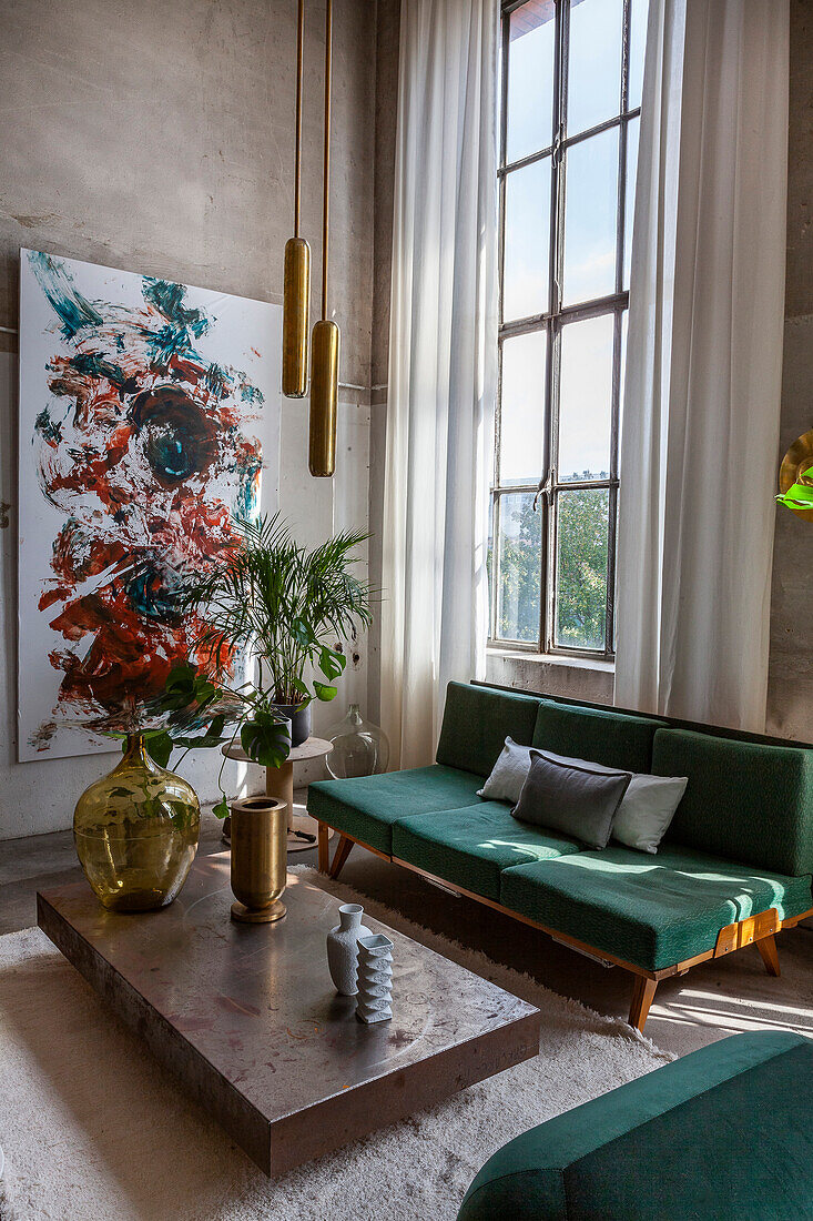 Green velvet sofa and abstract painting in the loft living room