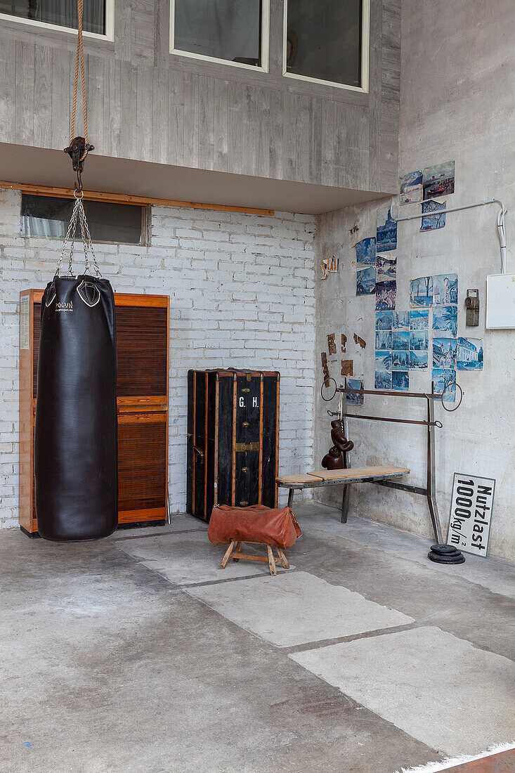 Loft corner with punching bag, rustic cabinet and wall decoration made from postcards