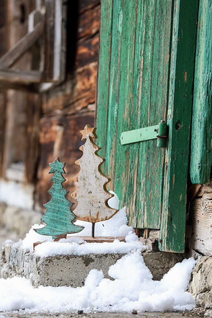 Tannenbäumchen aus Holz auf Steintreppe mit Schnee