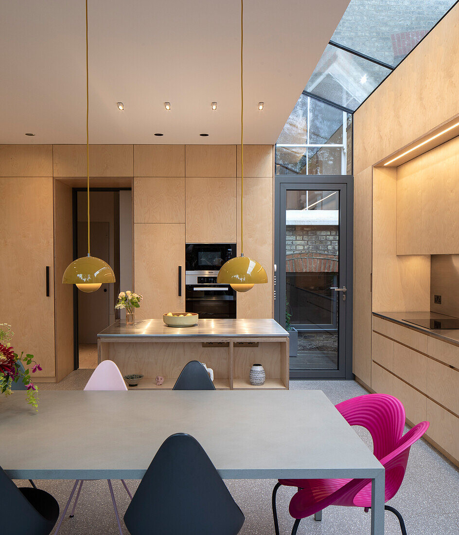 Mittelblock und Essbereich in offener Küche mit Glasdach