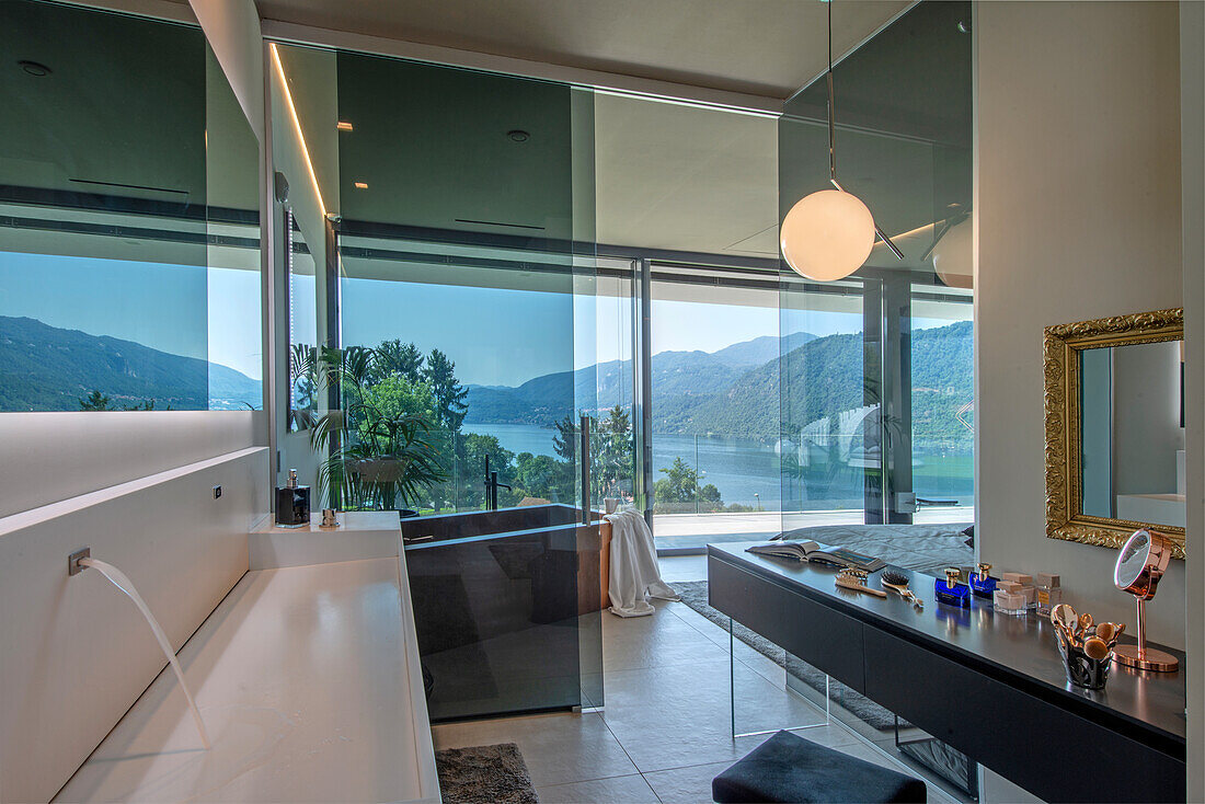 Modern bathroom with panoramic view of a lake and mountains