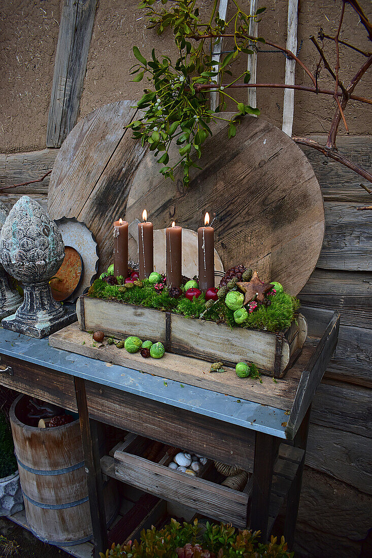 Adventsgesteck mit braunen Kerzen im Holzkästchen