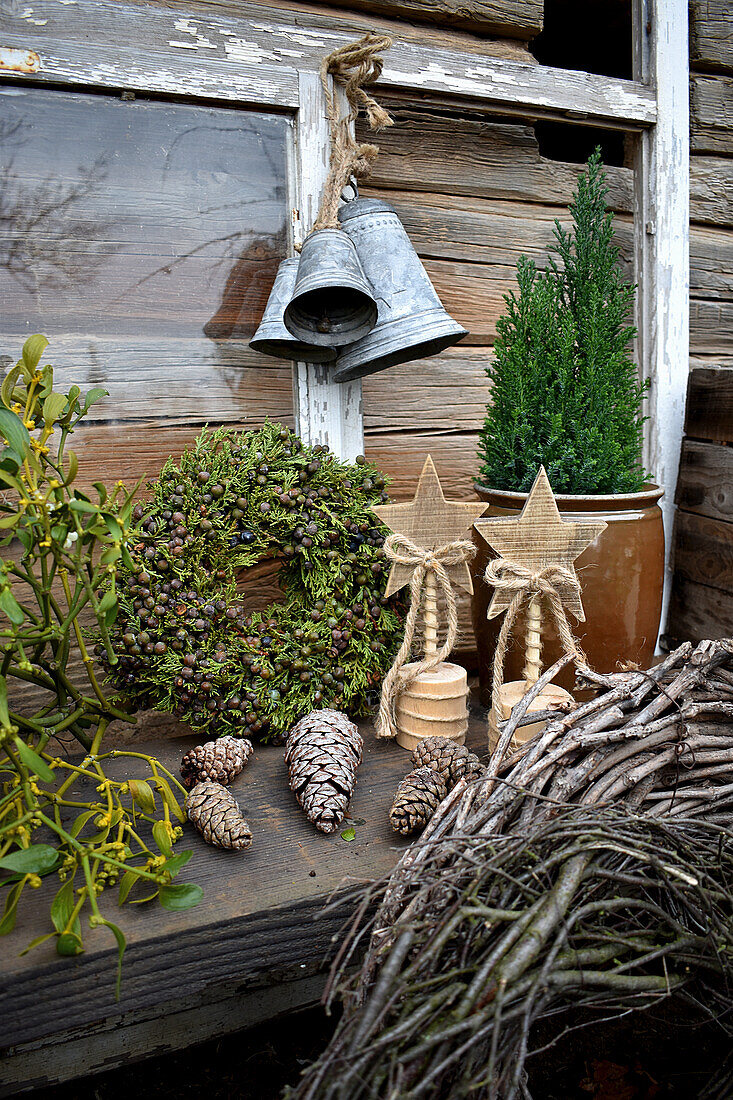 Wooden stars, bells, Thuja wreath and mistletoe on garden table