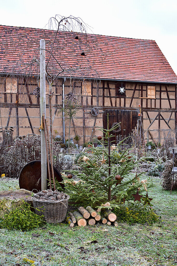 Christmas tree with wooden decorations in front of barn