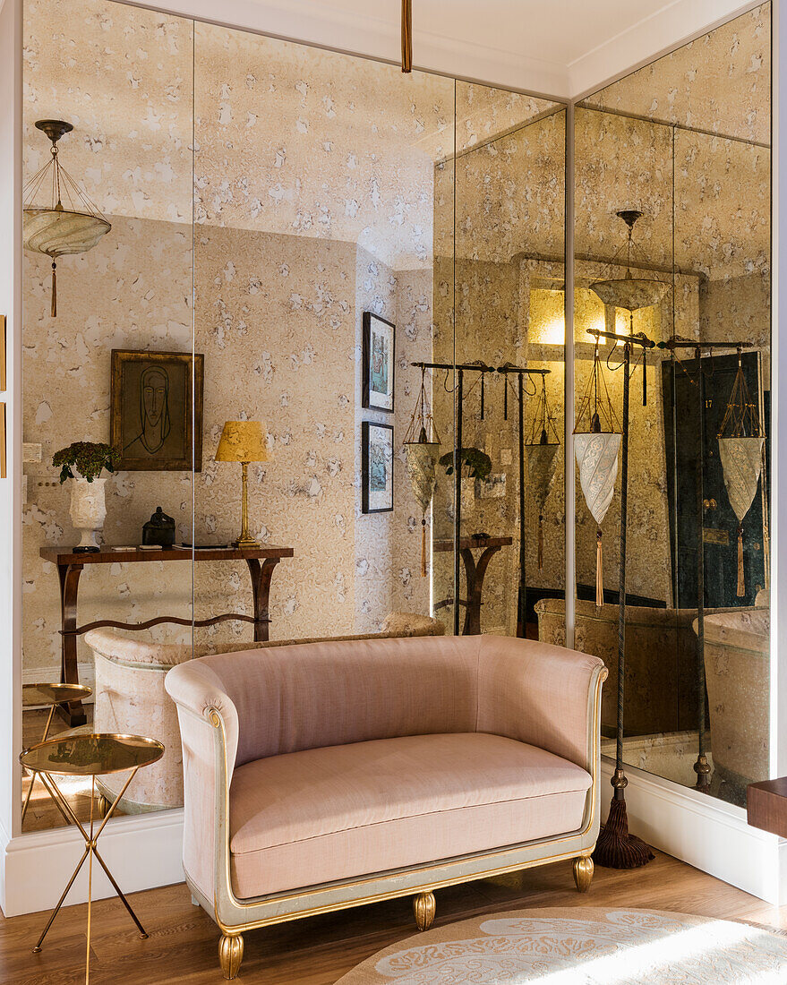 Französisches Zweisitzer-Sofa im Vintage-Stil mit rosafarbenem Samtbezug vor Spiegelwand