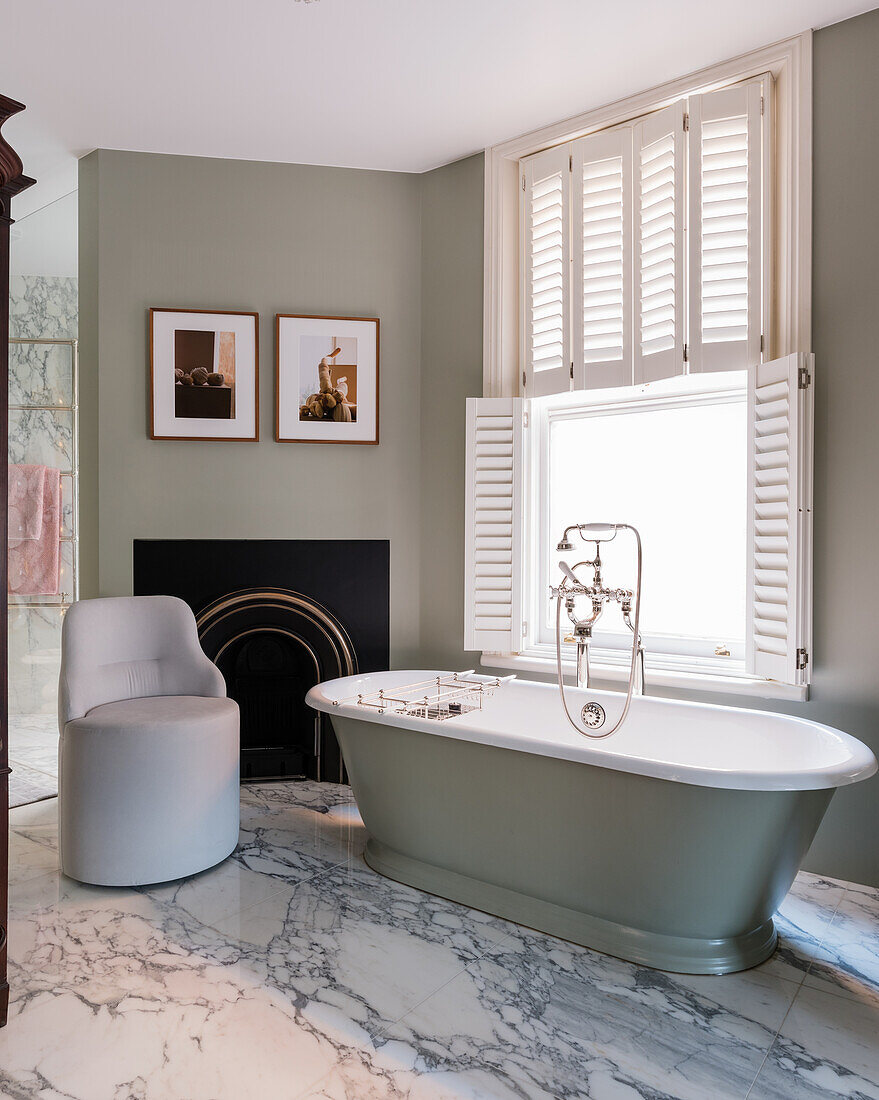 Freestanding bath at frosted glass window with plantation shutters