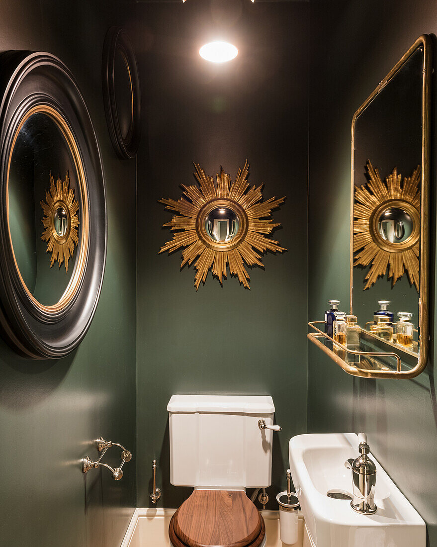 Green washroom with vintage mirrors giving idea of space