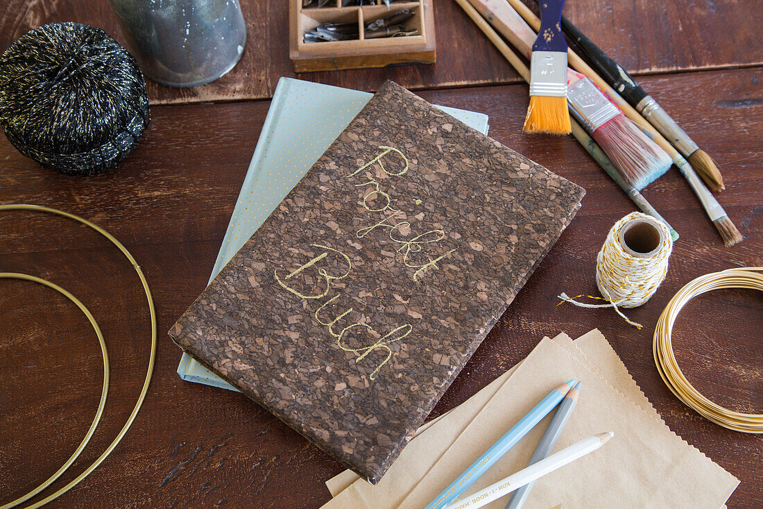 DIY project book on a wooden table with craft materials