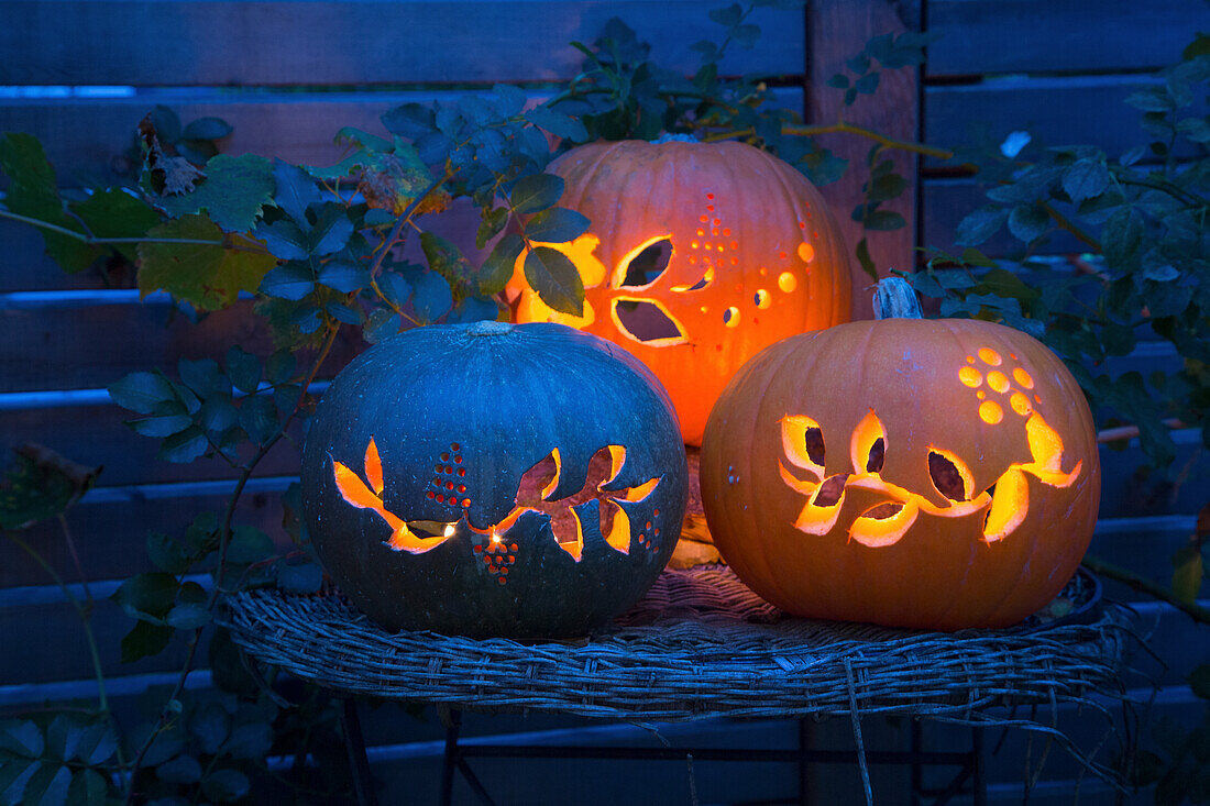 Hollowed-out pumpkins with lighting on a rattan side table