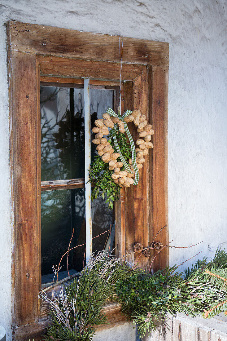 DIY-Kranz aus Erdnüssen an rustikalem Fenster