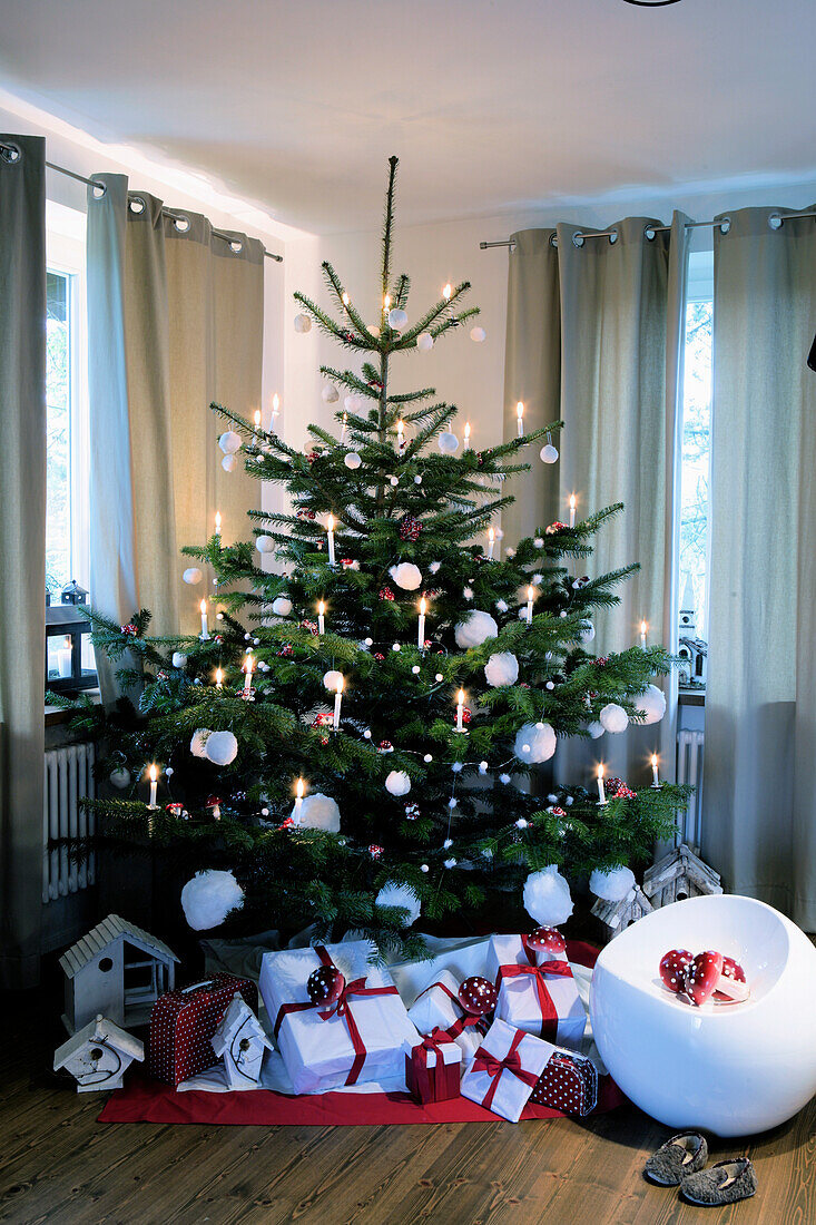 Geschmückter Weihnachtsbaum, darunter verpackte Geschenke