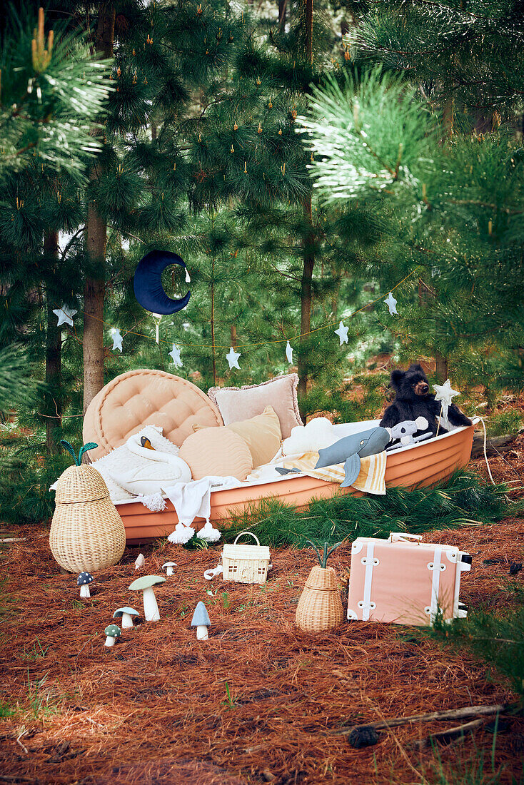 Boat with cushion and teddy bear and suitcase in the forest - gift idea for children