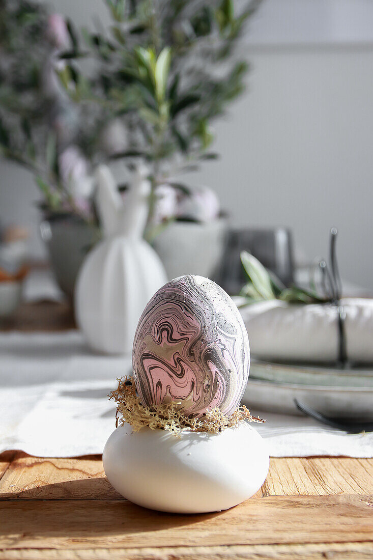 Marmoriertes Ei als Osterdekoration auf gedecktem Tisch