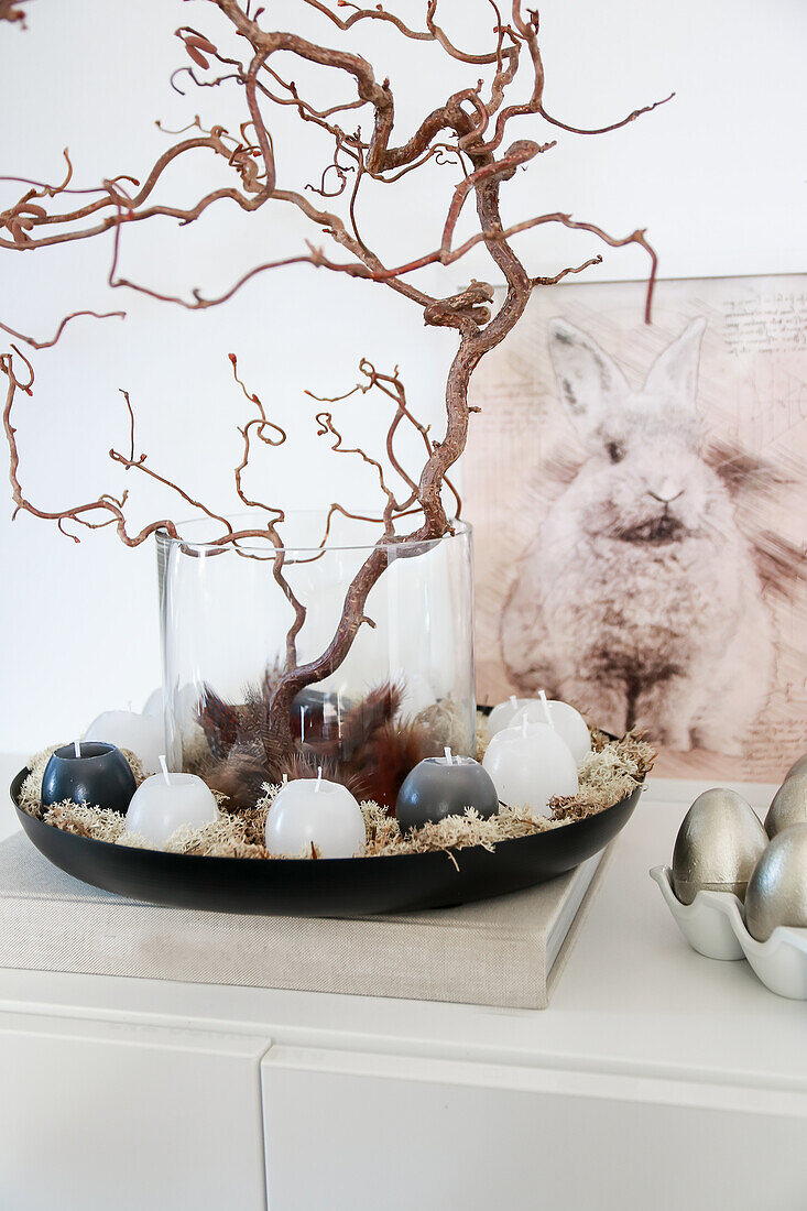 Decorative Easter arrangement with branches and candles, bunny picture and silver eggs