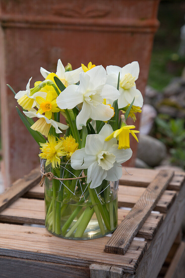 Daffodils in glass vase on wooden box