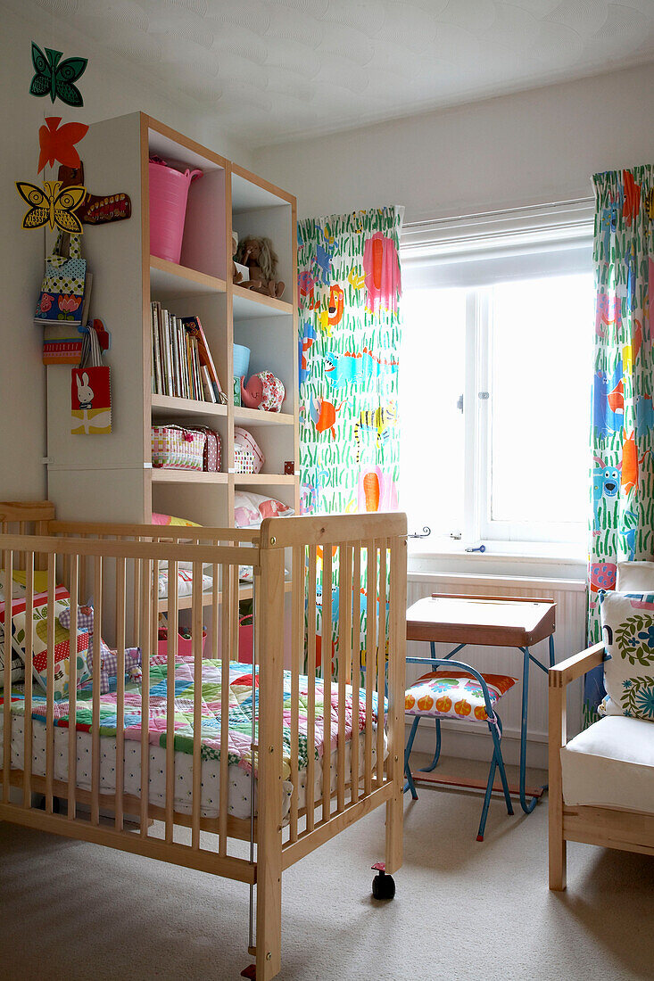 Childs colourful nursery room with multi coloured accessories and wooden cot