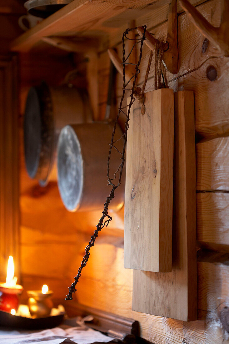 Küchenutensilien und brennende Kerzen in einer Blockhütte in Svartadalen, Schweden