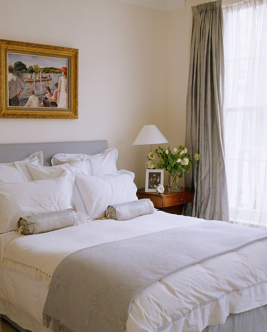 Traditionelles Schlafzimmer in Grau und neutralen Farben, Doppelbett mit gepolstertem Kopfteil, Vorhängen, Nachttisch