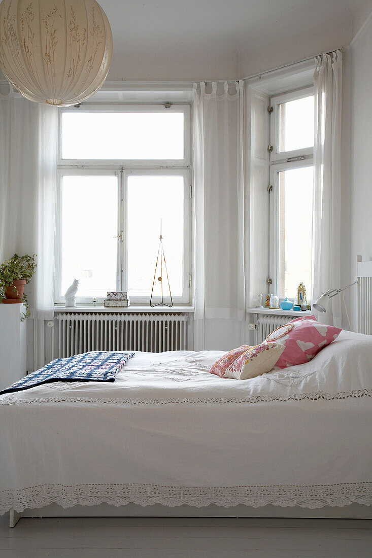 Weißes, sonnendurchflutetes Schlafzimmer in einer Stockholmer Wohnung aus dem 20. Jahrhundert