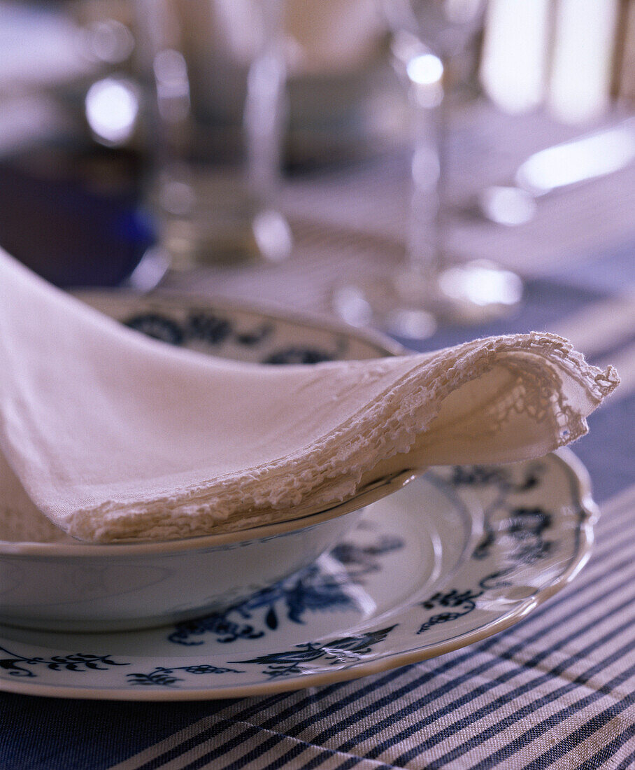 Gedeckter Tisch mit Serviette auf blauem und weißem Geschirr