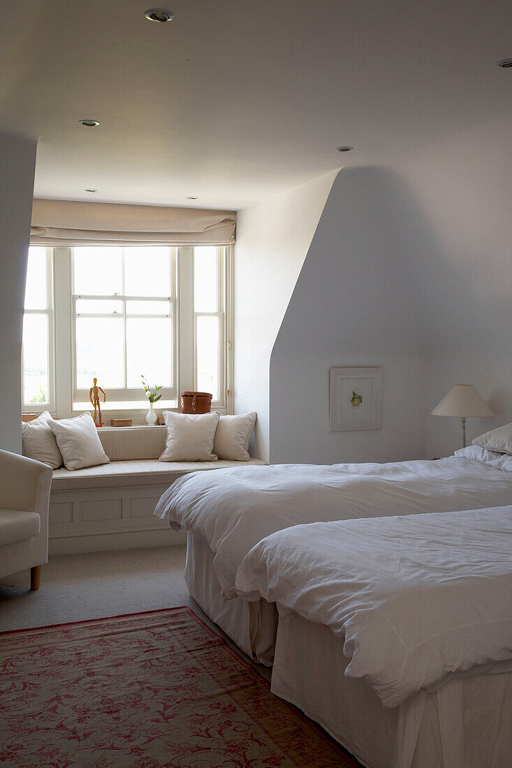 Zwei Einzelbetten in einem Cottage-Schlafzimmer mit sonnenbeschienener Fensterbank in Arundel, West Sussex