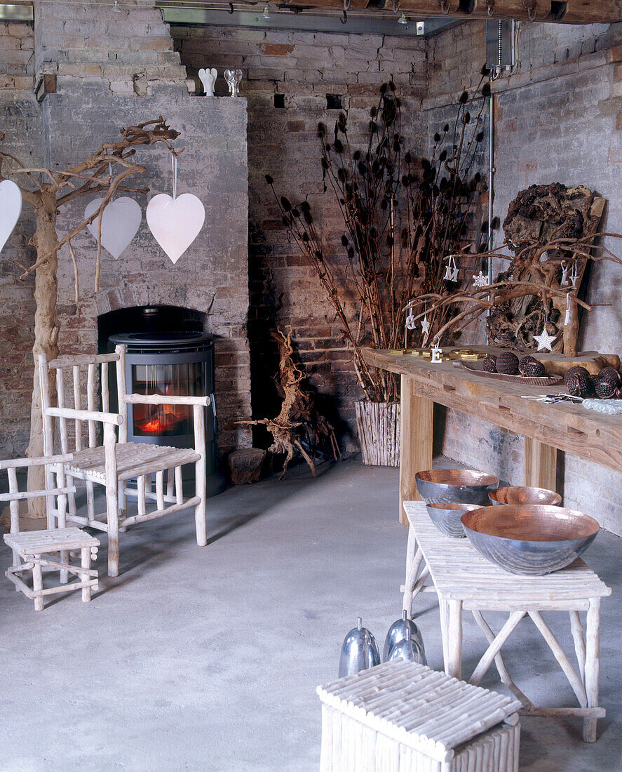 Raum mit Ziegelwänden, Betonboden, rustikalen Möbeln und einem kleinen Ofen