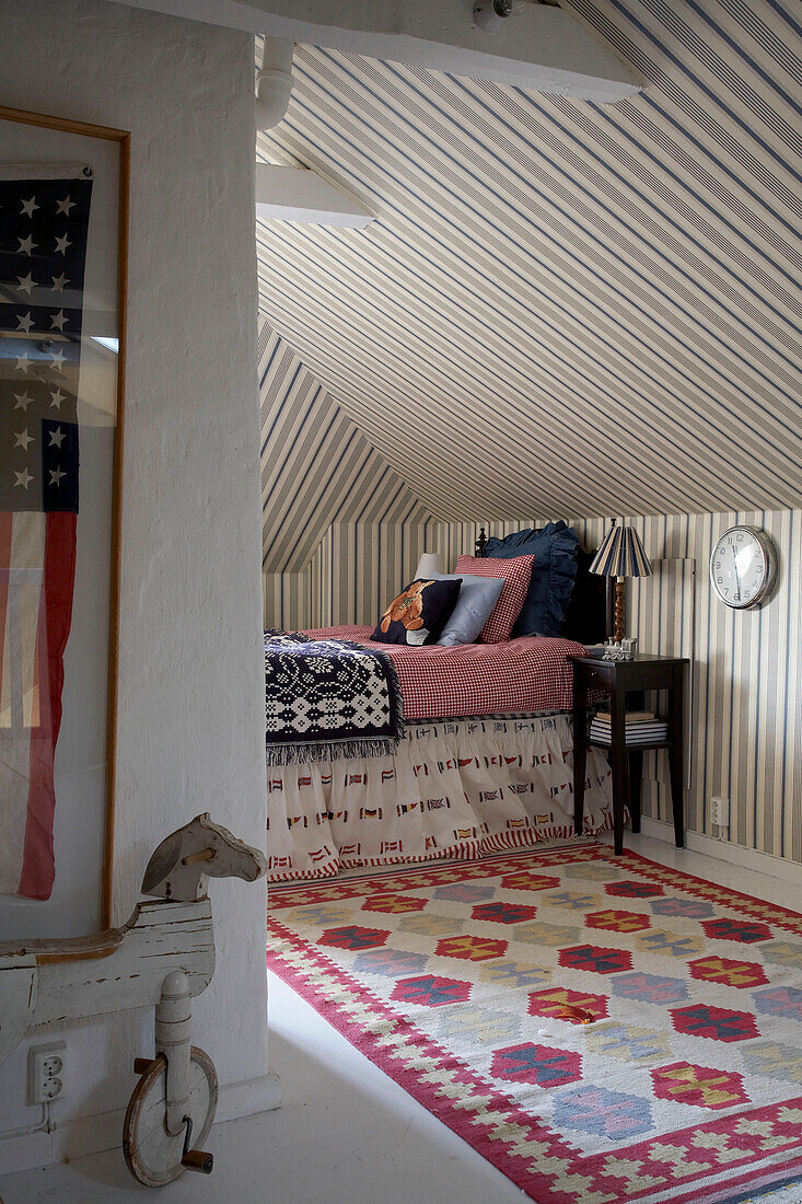 Child's room with patterned rug and wallpapered ceiling